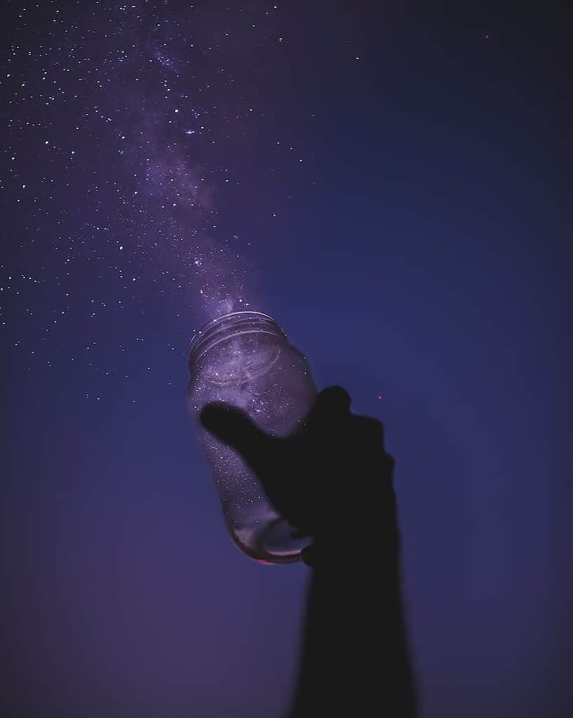 Person holding a glass jar, as a metaphor for keeping or chasing a dream