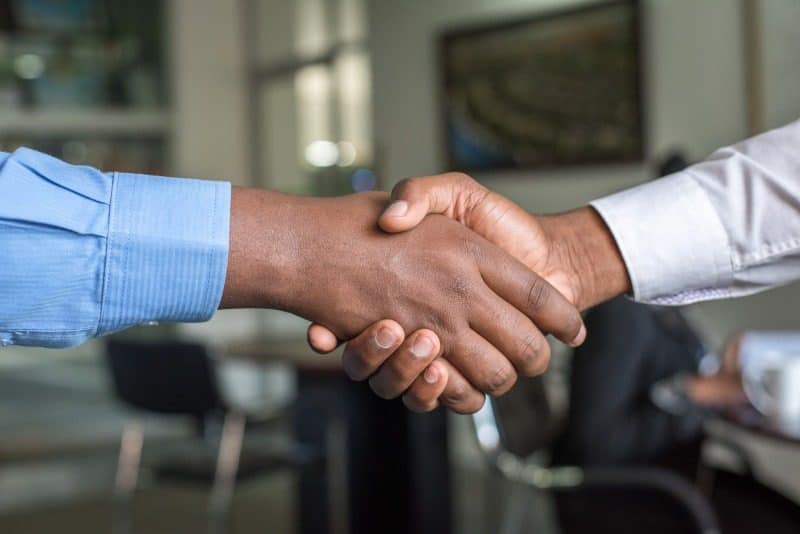 A handshake that represents collaboration within the team.