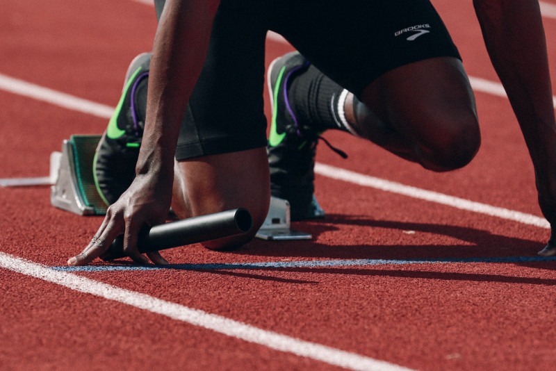 Atleta en pista listo para iniciar una carrera de relevos