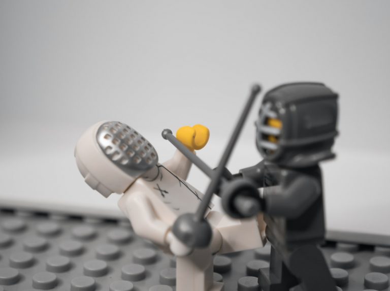 Zwei Lego-Fechtfiguren kämpfen in Anlehnung an den Kampf EDT gegen Backlog.