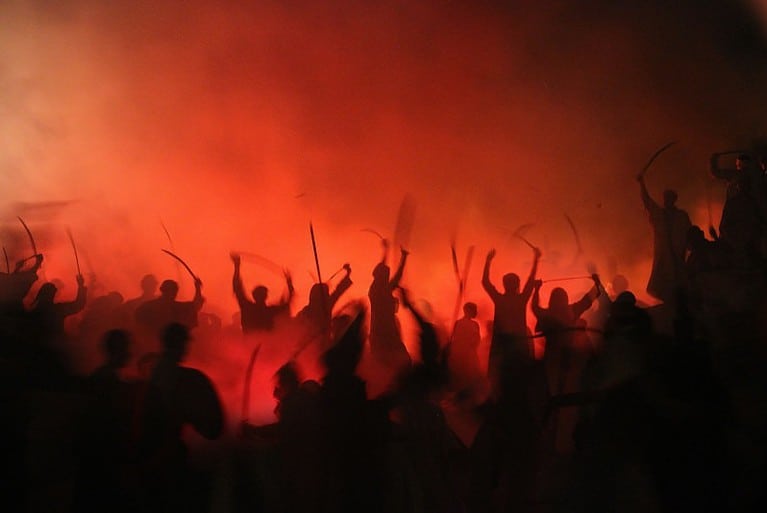 Sombras de gente reuniéndose durante la noche para una protesta
