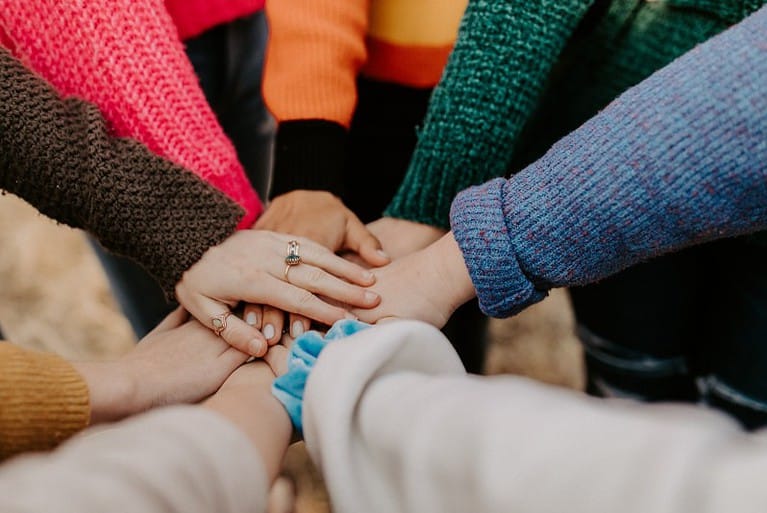 Photo of several hands on top of each other as a team