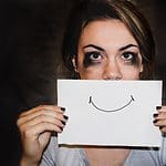 person holding white printer paper with a smile