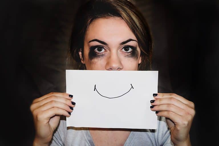 person holding white printer paper with a smile